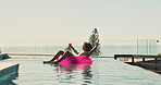 Float, drink and man in swimming pool at holiday home for relax in summer on vacation or weekend trip. Dancing, calm and person on inflatable with alcohol beverage in water for sunbathing at resort.