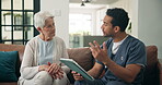 Tablet, talking and nurse with old woman on sofa for medical, advice, support or retirement. Elderly care, online healthcare report and caregiver with senior patient and man with tech in nursing home