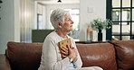 Sad, old woman and thinking with photo frame on sofa for loss, nostalgia or sorrow in retirement. Lonely widow, senior person with depression and hug picture in home for memory, broken heart or grief