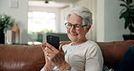 Typing, phone and smile with old woman on sofa for social media, ebook subscription and app. Online library, retirement and happy with senior person and tech in living room of home for weekend break
