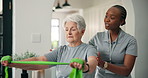 Senior woman, physiotherapist and patient with resistance band for strength training in home. Elderly, female person or physio helping client with flexibility for muscle recovery, fitness or exercise