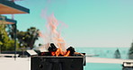Empty, pool and bbq with fire outdoor for party, holiday and lunch on weekend in backyard. Cookout, barbecue and grill with flame, wood and heat for social gathering, celebration and vacation