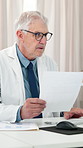 Documents, doctor and man in clinic, healthcare and checklist for schedule, email and reading. Mature person, medical service and professional in hospital, paperwork and administration with planning