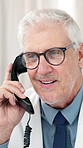 Telephone call, doctor and man with healthcare update, funny conversation and telehealth in hospital. Landline, mature person and medical worker speaking to contact for consultation, report or laugh
