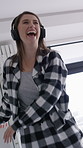 Woman, happy and dancing in bedroom with headphones, laugh and excited with streaming service in home. Girl, smile and listen to music with subscription, audio and rhythm with pyjamas at apartment