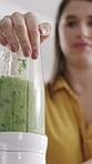 Woman, blender and green juice with smoothie in kitchen for nutrition, vitamins or diet in home. Hand, female person or nutritionist with mixer, ingredients or organic food for health detox in house