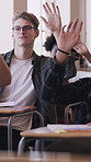 Student, question and raised hands with boy in classroom for learning, knowledge or studying. Academy, future development and education with person on campus for college entrance exam prep and answer