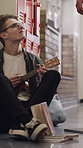 Bullying, education and guitar with student on floor of university corridor for music study. Break, male musician and playing instrument with bully kicking books of sad victim on college campus