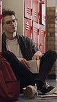 Education, bully and teen in high school with books, peer conflict and exclusion in hallway. Frustrated, victim and male person in lobby with reading, student issue and harassment on campus.