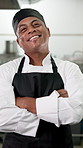 Face, man and chef with arms crossed in restaurant kitchen for career pride in hospitality industry. Portrait, male person or professional cook with smile, quality assurance and ambition for catering