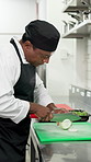 Chopping onions, cooking and meal with man in commercial kitchen for cuisine or hospitality. Food preparation, knife and slicing with chef in restaurant for fine dining, organic ingredients or recipe