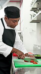 Chopping tomato, cooking and food with man in commercial kitchen for cuisine or hospitality. Cutting, knife and meal preparation with chef in restaurant for fine dining, organic ingredients or recipe