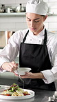 Culinary, plating or woman in kitchen with sauce, catering or presentation in luxury cuisine. Hospitality, skill or chef in restaurant with dish, aesthetic dinner or food decorating in fine dining.