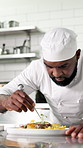 Chef, man and food presentation with herbs in kitchen for fine dining, culinary skill or aesthetic. Hospitality, black person and plating with garnish in restaurant for flavor, meal prep and catering