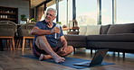 Water, yoga and senior woman on laptop in home for mindfulness, wellness and calm on floor. House, online class and mature person drinking for hydration, health and recovery from exercise in morning