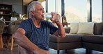 Senior man, drinking water and exercise in home, rest or smile for reflection in living room. Elderly person, bottle and hydration on floor, happy and thinking for wellness, fitness or break in house