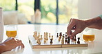 Hands, playing and people with chess in home for strategy development, bonding or contest. Competition, learning and man with woman for board game with moving pieces for challenge in apartment.