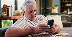 Phone, relax and senior man on sofa in home with texting, social media or chatting on mobile app. Happy, technology and elderly male person with cellphone for reading blog post in living room.