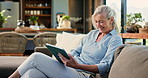 Tablet, happy and senior woman on sofa in home with reading comedy blog on app for entertainment. Laughing, digital technology and elderly female person on social media in living room at house.