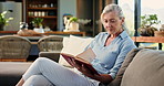 Senior woman, relax and reading book on sofa in home with story, literature and poetry for language. Elderly person, information and knowledge with novel, fiction and learning in lounge at apartment