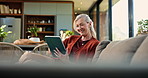 Tablet, smile and senior woman on sofa in home with reading comedy blog on app for entertainment. Laughing, digital technology and elderly female person on social media in living room at house.
