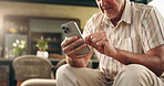 Hands, old man and relax with phone at house for browsing website, social media and message update. Smile, senior person and mobile app for reading blog, download games and notification for texting