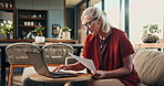 Finance, laptop and senior woman in home with paperwork for online banking, payment and savings. Retirement, documents and elderly person with bills for pension fund, budget planning and taxes