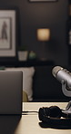 Desk, laptop and headphones with microphone, podcast and radio for online broadcast in empty office. Recording studio, computer and audio tech for live streaming, talk show and social media network.