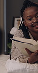 Woman, influencer and reading book with talk for content creation, camera or literature for children. African person, happy and online tutorial on social media, story or recording on bed at house
