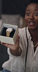 Black woman, influencer and unboxing in home, watch or talk with online audience for product review. African person, cardboard package and presenter on social media, live stream or jewelry for video
