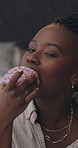 Black woman, face and vlogger eating with donut for online review, rating or social media in home. Portrait, female person or food critic with icing dessert or snack for taste or feedback in house