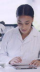 Investigation, microscope and tablet with woman in laboratory for medical or pharmaceutical research. App, healthcare and science with person at work on technology for analysis or clinic trial
