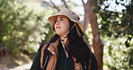 Woman, trekking and outdoor adventure with forest scenery for tourist exploration, wellness and journey. Person, hiking and walking with backpack for travel, holiday activity and nature sightseeing.
