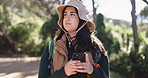 Woman, phone and hiking in forest, thinking and search for location, direction or confused on holiday. Person, smartphone and lost with mobile app, nature tourism or scroll on map with bag in woods