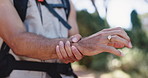 Hands, wrist pain and hiking in forest with injury, carpal tunnel or massage for tendinitis on adventure. Person, trekking and joint ache with inflammation, fatigue or burnout with arthritis in woods
