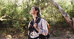 Woman, hiking and outdoor adventure with bag in forest for tourist exploration, wellness and journey. Female person, trekking or walking with backpack for travel, holiday activity and nature scenery.