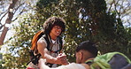 Men, friends and helping hand for hiking in forest, happy and backpack for adventure on vacation. People, smile and support with outdoor for challenge, trekking or tourism with teamwork in woods