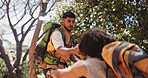Men, friends and helping hand for hiking in woods, happy and backpack for adventure on vacation. People, smile and support with outdoor for challenge, trekking or tourism with teamwork in forest