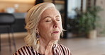 Woman, breathing or relax in house with meditation for wellness, spiritual healing or peaceful moment. Zen, mature person and breathwork in living room with mindfulness, stress relief or tranquility.
