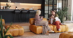 Coffee, gossip and mature friends on sofa in home with bonding, connection or communication. Warm beverage, conversation and women with relax and talking in living room together at apartment.