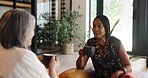 Friends, home and women with coffee, bonding and relax with gossip, happy and conversation on break. Mature people, discussion and together with tea in lounge, smile and listening to story in house