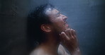 Man, dark shower and crying at glass in bathroom, stress and mental health with ptsd for sad memory. Person with depression, blur and anxiety with water drops, trauma and frustrated at apartment