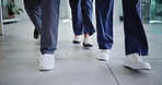 Feet, shoes and doctors walking in hospital hallway for healthcare support, career or teamwork. Collaboration, group and professional medical employees in lobby for ER help or service in clinic.