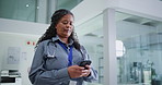 Woman, doctor and typing in hospital with phone for text message, check schedule or medical update. Walking, mature person or healthcare worker in clinic with tech for website, reading news or email.