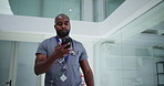 Black man, doctor and walk in hospital with phone for schedule check, text message and medical update. Low angle, person and healthcare worker in clinic with tech for email, research or reading news.