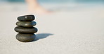 Beach, stones pile and stack with balance, wellness and zen with sand, vacation and peaceful. Rocks, ocean and natural with mindfulness, water and calming with summer holiday, seaside and tourism