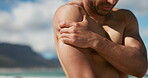 Fitness, massage or hands at beach with shoulder pain, cardio injury or physical risk in exercise. Sports, tension or athlete at ocean with joint inflammation, tendinitis or muscle strain in workout.