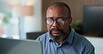 Businessman, review and reading in office with laptop for finance proposal, budget report and research. Mature, black person and glasses in workplace with computer, financial planning and evaluation.