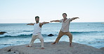 People, yoga and warrior pose at ocean with fitness for wellness, holistic health and coordination. Active, men outdoor and pilates with exercise at beach for stretching, balance and inner peace.