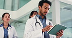 Tablet, walking and man in hallway, doctors and email for healthcare policy, schedule and report. Group, medical service and employees in lobby, app or website info for diagnosis or online checklist